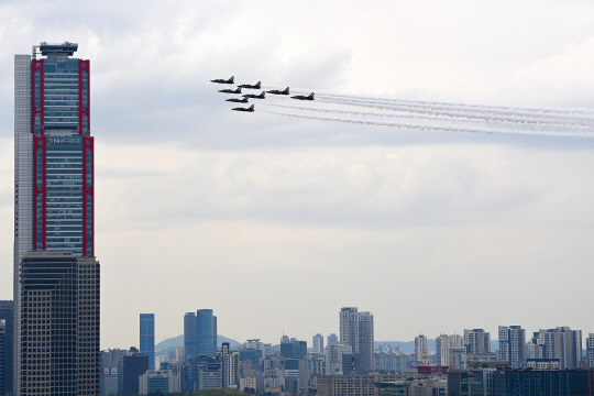 공군 특수비행팀 블랙이글스가 4일 서울 도심 상공에서 봄꽃축제 개막을 축하하는 에어쇼를 펼치며 고층빌딩 옆을 지나고 있다. 백동현 기자