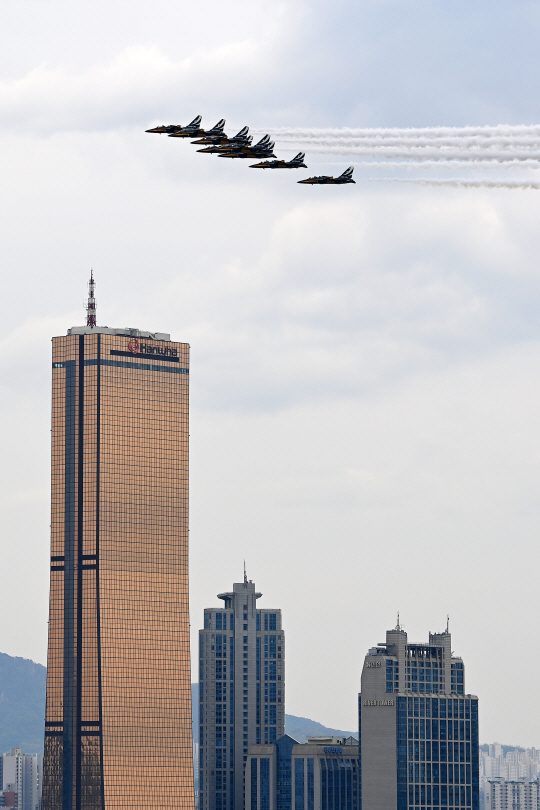 공군 특수비행팀 블랙이글스가 4일 서울 도심 상공에서 봄꽃축제 개막을 축하하는 에어쇼를 펼치며 고층빌딩 옆을 지나고 있다. 백동현 기자