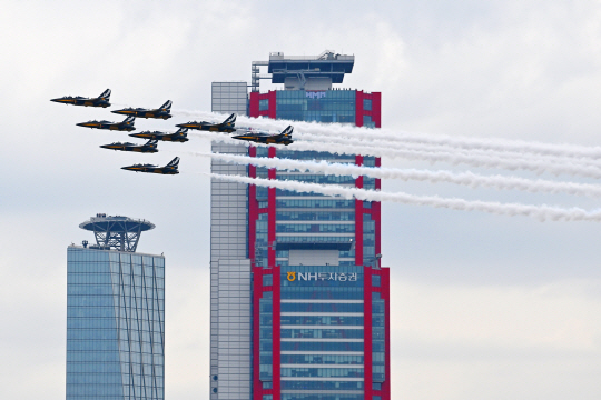공군 특수비행팀 블랙이글스가 4일 서울 도심 상공에서 봄꽃축제 개막을 축하하는 에어쇼를 펼치며 고층빌딩 옆을 지나고 있다. 백동현 기자
