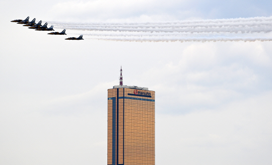 공군 특수비행팀 블랙이글스가 4일 서울 도심 상공에서 봄꽃축제 개막을 축하하는 에어쇼를 펼치며 고층빌딩 옆을 지나고 있다. 백동현 기자