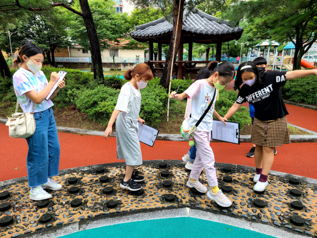 경북 상주시 종합사회복지관의 ‘놀 권리 탐구단’ 프로그램에 참여한 상주초 학생들이 지난해 8월 상주 시내 놀이터를 탐방하면서 보고서를 작성하고 있다.  초록우산어린이재단 제공