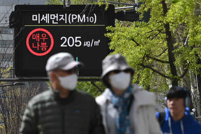중국에서 유입된 고농도 황사로 인해 미세먼지(PM10) 농도가 ‘매우 나쁨’을 보인 12일 오전 서울 중구 시청역 앞 전광판 앞으로 시민들이 마스크를 쓴 채 걸어가고 있다. 백동현 기자
