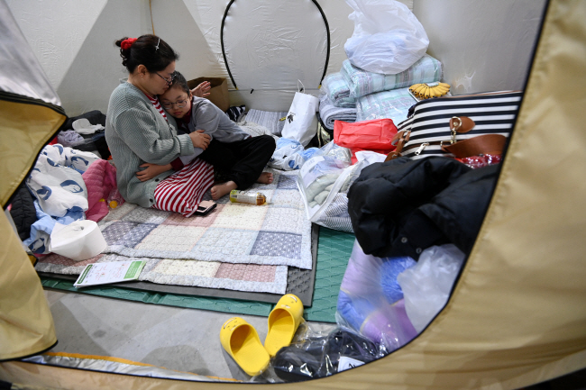 12일 강원 강릉시 아이스 아레나에 마련된 산불 피해 임시 대피소에서 최영주(44) 씨가 딸 우승연(11) 양을 안아주고 있다. 최 씨는 갑자기 들이닥친 산불에 아기 약과 핸드백만 가지고 서둘러 몸만 빠져나왔다며 앞으로의 생활이 막막하다고 말했다.  문호남 기자