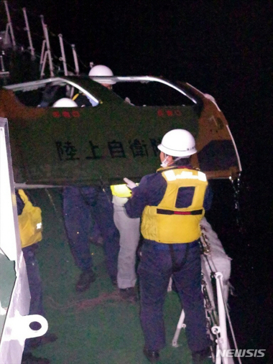지난 7일 일본 남부 오키나와현 미야코섬 앞바다에서 해안경비대원들이 해안경비대원들이 헬기 문을 회수하고 있다. 문에 적힌 문구는 육상자위대다.AP뉴시스