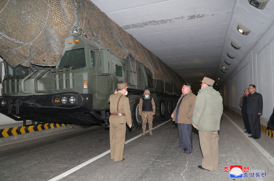 김정일 북한 국무위원장이 지난 13일 발사에 앞서 도로 터널에 엄폐돼 발사 대기 중인 화성-18형 미사일을 살펴보고 있다. 조선중앙통신 캡처