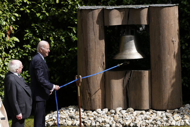 13일 조 바이든 미국 대통령이 아일랜드 더블린의 대통령 관저에서 마이클 히긴스 아일랜드 대통령이 지켜보는 가운데 평화의 종을 울리고 있다. AP 연합뉴스