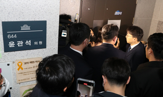 검찰 수사관들이 지난 12일 오전 국회 의원회관 윤관석 더불어민주당 의원실 앞에서 압수수색을 하기 위해 대기하고 있다. 윤 의원은 2021년 5월 민주당 전당대회 당시 송영길 전 대표를 당 대표로 당선시키기 위해 불법 정치자금을 수수한 혐의를 받고 있다. 뉴시스