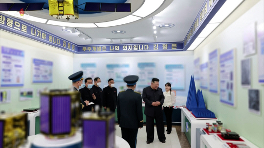 북한 김정은 국무위원장이 지난 18일 국가우주개발국을 현지지도하는 영상을 조선중앙TV가 19일 보도한 가운데 무게 200∼300으로 추정되는 육각 기둥 형상의 소형 정찰위성 여러개가 눈에 띈다.조선중앙TV 캡처／연합뉴스