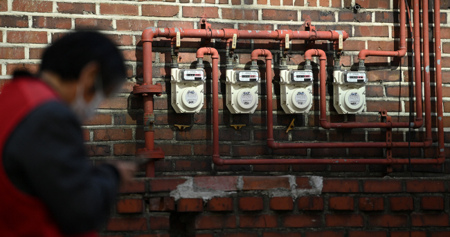 정부가 올해 2분기 전기·가스료 인상 여부 결정을 늦추고 있는 가운데 19일 오전 서울의 한 주택가에 설치된 가스계량기 앞을 행인이 지나가고 있다.     백동현 기자