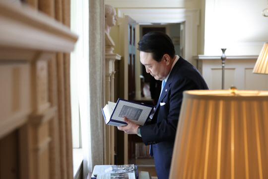 윤석열 대통령이 24일(현지시간) 워싱턴에 위치한 미국 영빈관 ‘블레어하우스’에서 소장 도서를 살펴보고 있다. 뉴시스(공동취재)