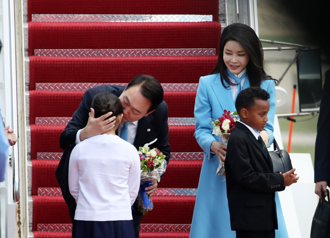 24일 미국 워싱턴DC 인근 앤드루스 공군기지에 도착한 윤석열 대통령이 꽃다발을 선물한 화동에게 뽀뽀하고 있다. 뉴시스