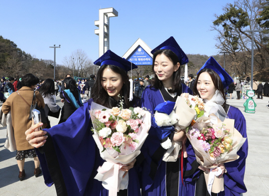 서울대학교 졸업생들이 지난 2월 24일 서울 관악구 서울대학교 정문 앞에서 2023년 서울대학교 제77회 학위수여식을 앞두고 기념촬영을 하고 있다. 뉴시스
