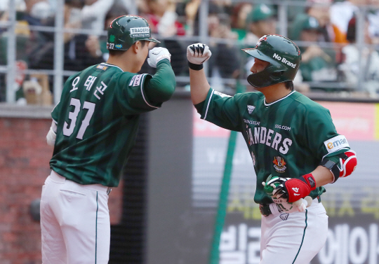 SSG의 최정(오른쪽)이 28일 인천랜더스필드에서 열린 두산과의 경기에서 1회 말 솔로 홈런을 터뜨리고 득점을 올린 뒤 한유섬과 하이파이브를 나누고 있다. SSG 제공