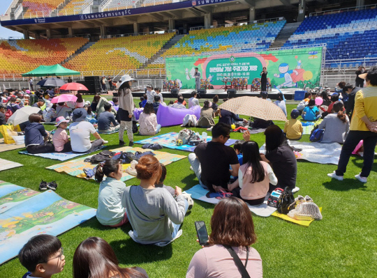 지난 2019년 5월 6일 경기 수원시 우만동 수원월드컵경기장에서 열린 ‘어린이날 기념 주경기장 개방행사’에서 관람객들이 돗자리에 앉아 여가를 즐기고 있다. 경기도수원월드컵경기장관리재단 제공