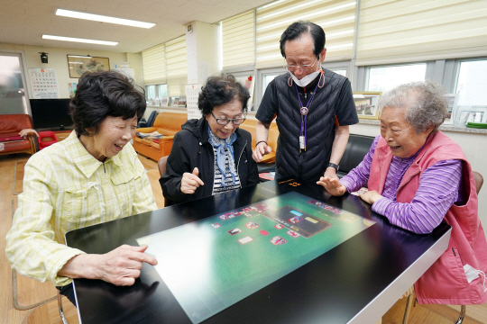 답십리3동경로당을 이용하는 어르신들이 스마트 테이블을 활용해 치매예방 게임을 즐기고 있다. 동대문구청 제공
