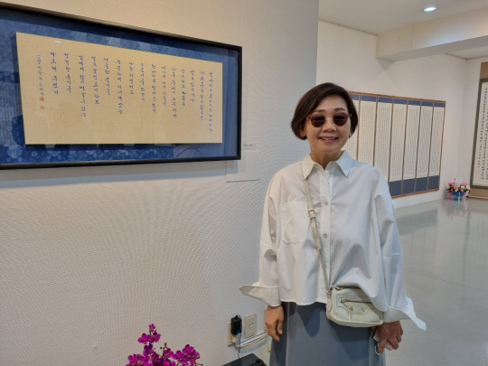 산샘 박찬희 작가가 전시 중인 작품을 배경으로 포즈를 취하고 있다