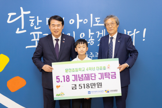 광주 문산초등학교 4학년 신준호(가운데) 군이 지난 16일 광주시교육청을 방문해 518만 원을 기부했다. 광주시교육청 제공