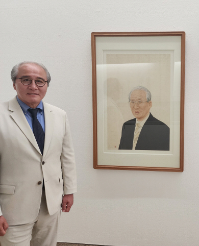 박우홍 동산방화랑 대표가 부친인 박주환 창업자 초상화(김호석 작) 옆에서 포즈를 취했다.