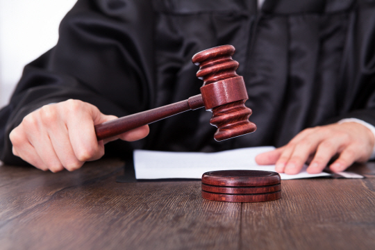 Close-up Of A Judge Hitting Mallet At Desk