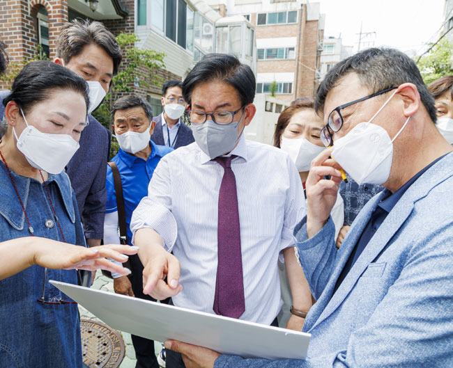 박강수(가운데) 마포구청장이 지난해 7월 성산동 모아타운 예정지를 방문해 정비계획을 검토하고 있다. 마포구청 제공