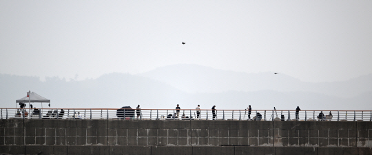 24일 한국형 우주발사체 누리호의 3차 발사를 관람하기 위해 전남 여수시 낭도방파제를 찾은 시민들 뒤로 나로우주센터가 있는 외나로도가 보인다. 백동현 기자