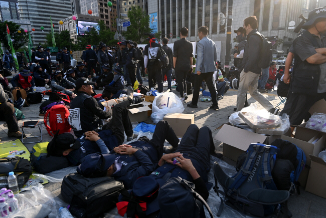 민주노총 건설노조가 서울 중구 세종대로 일대에서 ‘1박 2일 대규모 노숙 농성 집회’를 이어간 지난 17일 오전 도로를 점거한 노조원들로 인해 출근길 시민들이 통행에 불편을 겪고 있다. 윤성호 기자