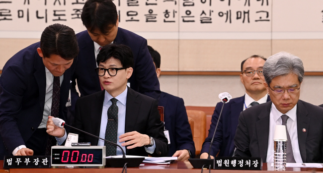 25일 오전 국회에서 열린 법제사법위원회 전체회의에 참석한 한동훈(왼쪽 두 번째) 법무부 장관이 법무부 관계자와 이야기를 나누고 있다. 오른쪽은 김상환 법원행정처장. 곽성호 기자