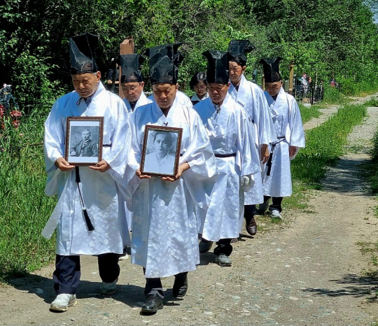 제례복을 차려입은 전주 최씨종중 최재형 선생 후손들이 선생의 부인인 최 엘레나  페트로브나 여사 묘지가 있는 키르기스스탄 비슈케크 세베르느이 공동묘지 진입로에서부터 최재형 선생 부부 영정을 들고 묘지를 향해 걸어가고 있다. 독립운동가최재형선생기념사업회 제공