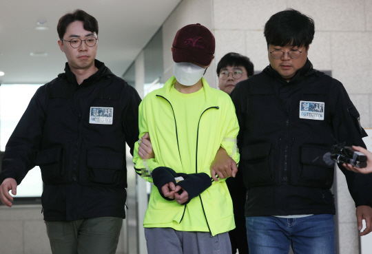 데이트 폭력으로 경찰 조사를 받은 직후 연인을 살해한 혐의로 구속영장이 청구된 김모(가운데) 씨가 28일 서울남부지법에서 열리는 구속영장심사를 받기 위해 금천경찰서를 나서고 있다. 연합뉴스