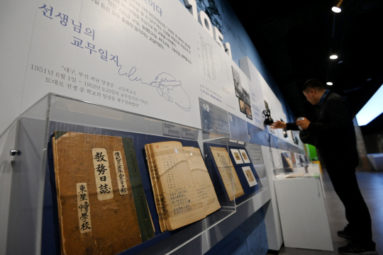 서울 서대문구 대한민국임시정부기념관에서 열린 ’고난 속에 피어난 기적, 피난시절 천막교실‘ 전시에서 한 시민이 전쟁 중 선생님의 교무일지를 살펴보고 있다. 문호남 기자