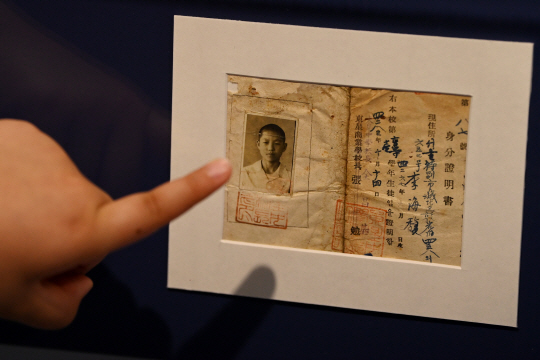 제68회 현충일을 이틀 앞둔 4일 서울 서대문구 대한민국임시정부기념관에서 열린 ’고난 속에 피어난 기적, 피난시절 천막교실‘ 전시에서 한 어린이가 1950년 10월 14일 발행된 동성중학교 1학년 학생증을 살펴보고 있다. 문호남 기자