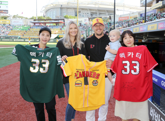 SSG의 외국인 투수 커크 맥카티(왼쪽에서 3번째)가 3일 인천SSG랜더스필드에서 열린 키움과의 경기를 앞두고 우는 딸을 달래준 팬들과 사진을 찍고 있다. SSG 제공