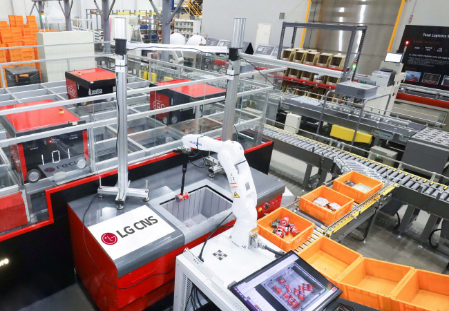 경기 안산의 한 물류 공장에서 LG CNS의 인공지능(AI) 피킹 로봇이 오토스토어(상품 보관·적재·이동이 가능한 자동화 로봇)로부터 과자를 집어 박스로 나르고 있다.  LG CNS 제공