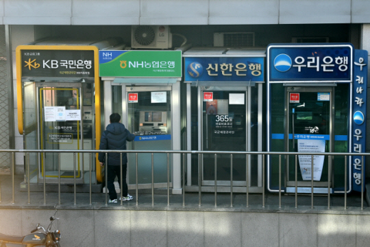 서울 시내에 설치된 시중은행의 현금인출기(ATM)를 이용하기 위해 내부로 들어서는 한 시민. 문화일보 자료 사진