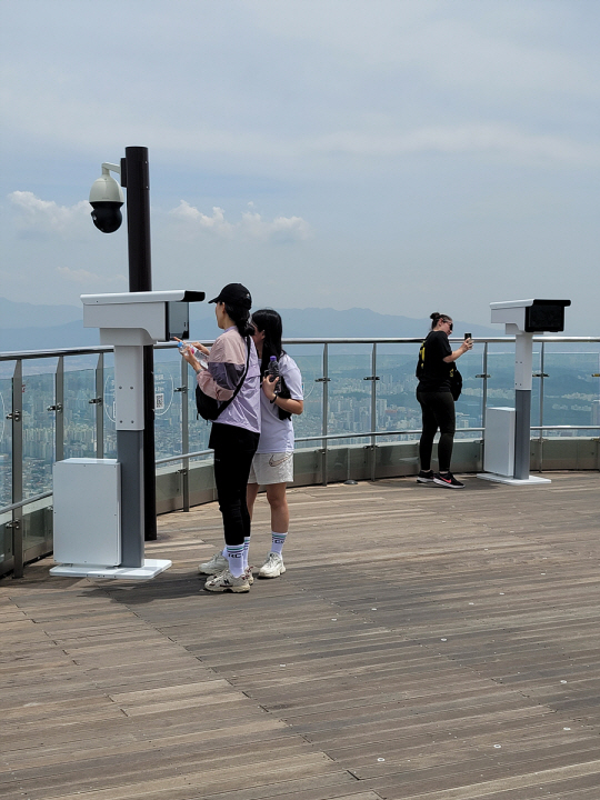 대구 남구 앞산 전망대에서 주민들이 확장현실(XR)망원경으로 도심 풍경을 보고 있다. 대구시청 제공