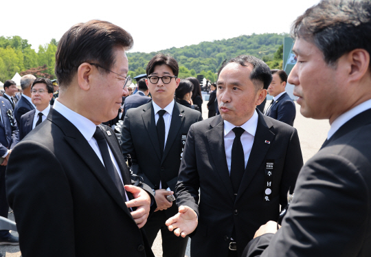 이재명(왼쪽) 더불어민주당 대표가 6일 서울 동작구 국립서울현충원에서 열린 제68회 현충일 추념식을 마친 뒤 최원일 전 천안함 함장으로부터 항의를 받고 있다. 대통령실통신사진기자단