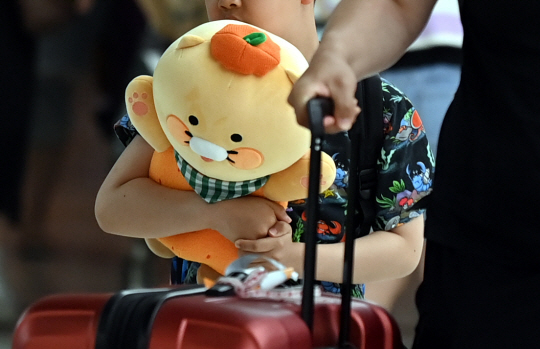 현충일 징검다리 연휴 마지막 날인 6일 오후 서울 강서구 김포공항 국내선 도착장에서 한 어린이가 감귤모자를 쓴 인형을 들고 들어오고 있다. 박윤슬 기자