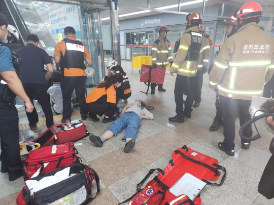 8일 오전 8시 19분쯤 경기 성남시 분당구 수내동 일원 수인분당선 수내역 2번 출구에서 상행 에스컬레이터 역주행으로 14명의 이용객이 부상을 당한 가운데 119 구급대원들이 다친 이용객들의 상태를 살피고 있다. 경기도소방재난본부 제공