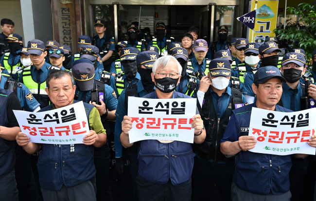 경찰이 지난 5월 16~17일 민주노총 건설노조가 개최한 서울 도심 ‘1박 2일 노숙집회’ 등과 관련해 9일 오전 서울 영등포구 대림동 건설노조 사무실을 압수수색하자 노조원들이 ‘윤석열 정권 규탄’ 피켓을 들고 시위를 벌이고 있다.  백동현 기자