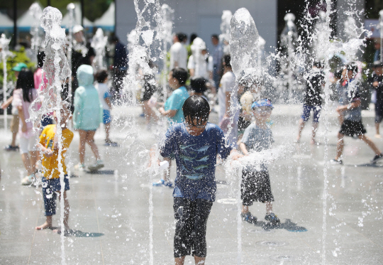 서울을 비롯한 중부내륙 곳곳에 폭염주의보가 내려진 18일 서울 종로구 광화문광장 분수에서 어린이들이 물놀이를 즐기고 있다. 뉴시스
