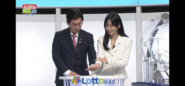지난 10일 ‘대국민 로또 6/45 추첨 공개방송’에서 최상대(왼쪽) 기획재정부 2차관과 배우 김소연이 로또 추첨기 버튼을 누르고 있다.  방송 화면 캡처