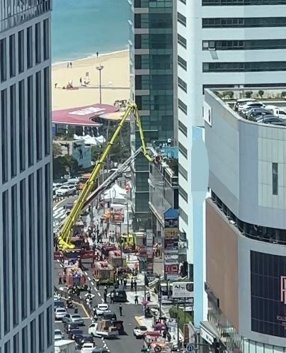 20일 오전 9시 33분쯤 부산 해운대구 한 호텔 건물 지하에서 불이나 소방당국이 고가사다리차를 활용해 투숙객을 구조하고 있다. 연합뉴스(독자 제공)