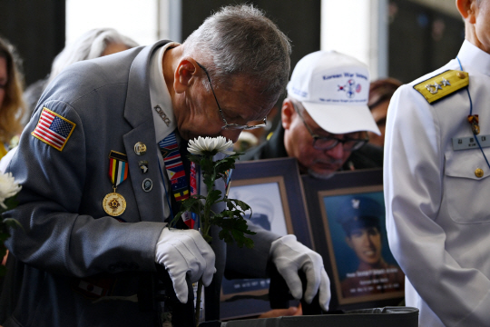 미국 참전 용사와 전사자·실종자 유가족이 서울 용산구 전쟁기념관에서 국화꽃을 든 채 고개 숙여 묵념하고 있다. 문호남 기자