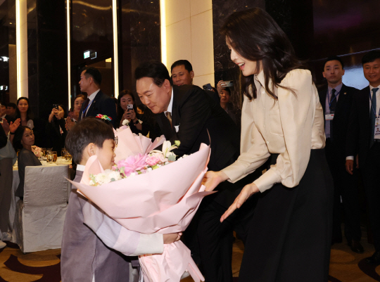 윤석열 대통령과  김건희 여사가 22일 베트남 동포 오찬 간담회에서 화동에게서 꽃다발을 받고 있다. 연합뉴스
