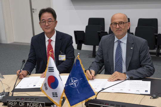 21일 벨기에 브뤼셀에서 열린 북대서양조약기구(NATO) 항공위원회에서 김진홍(왼쪽) 방위사업청 방위산업진흥국장이 NATO 관계자와  군용항공기 감항인증 상호인정 절차 착수를 위한 합의서에 서명하고 있다.연합뉴스