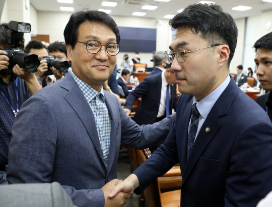 안민석(왼쪽) 더불어민주당 의원이 지난 12일 국회에서 열린 교육위원회 전체회의에서 무소속 김남국 의원과 악수하고 있다. 뉴시스