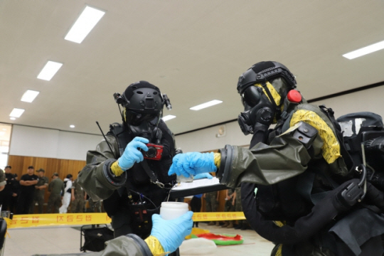 국방부는 28일 국군화생방방호사령부에서 화학무기 공격 및 테러 대응능력 제고를 위해 화학무기금지기구(OPCW)가 참여한 가운데 ‘한-OPCW 도상훈련’을 처음 개최했다. 화생방특수임무단 장병들이 OPCW 대표단 앞에서 대화생방테러작전수행절차 중 채취한 시료에 대한 채증 과정을 보여주고 있다. 국방부 제공