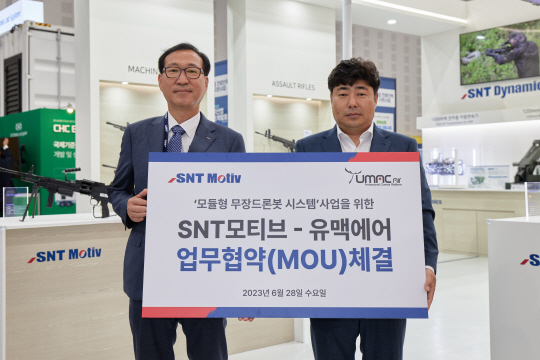 SNT모티브 권형순(왼쪽) 대표이사와 드론업체  유맥에어 최종필 대표이사가 28일 대전컨벤션센터에서 ‘모듈형 무장드론로봇 시스템’ 업무협약을 체결하고 기념촬영하고 있다. SNT모티브 제공