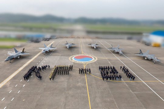 한국항공우주산업(KAI)가 28일로 KF-21 보라매 시제1~6호기 모두 시험비행에 성공한 것을 기념해 시제기 6대 앞에서 조종사들이 ‘KF-21 ’ 대형을 펼쳐보이고 있다. KAI 제공