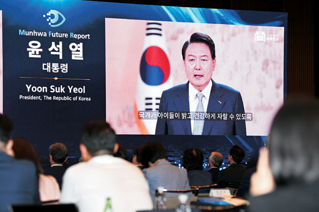 29일 서울 중구 대한상공회의소 국제회의장에서 열린 ‘문화미래리포트 2023’ 참석자들이 윤석열 대통령의 저출산 인구 감소 위기에 대한 전 사회적 논의 필요성을 강조하는 축사 영상 메시지를 보고 있다. 문호남 기자